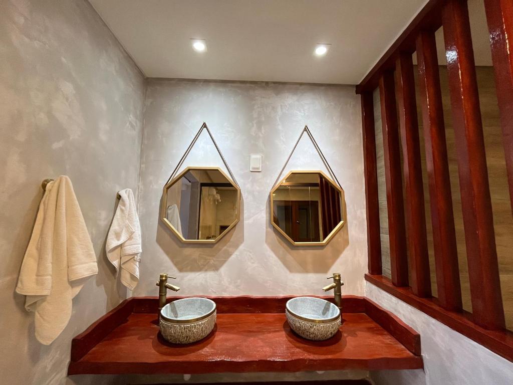 uma casa de banho com dois lavatórios e dois espelhos em Pousada Sete Mares em Maragogi