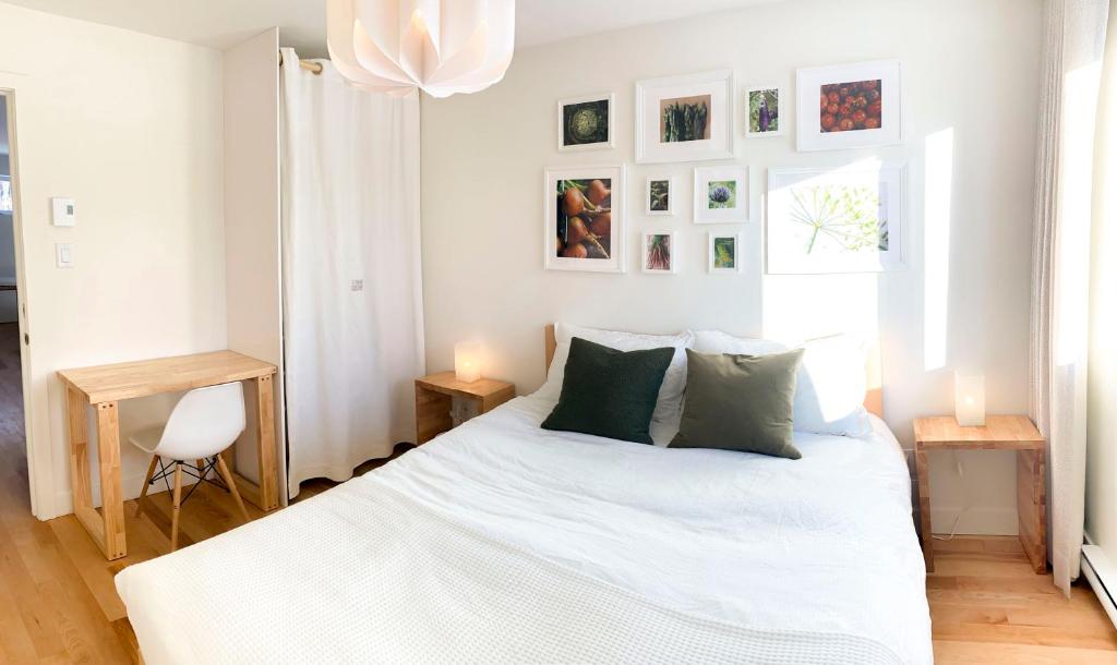 a bedroom with a bed with white sheets and green pillows at Le Camp Caché Shefford in Shefford