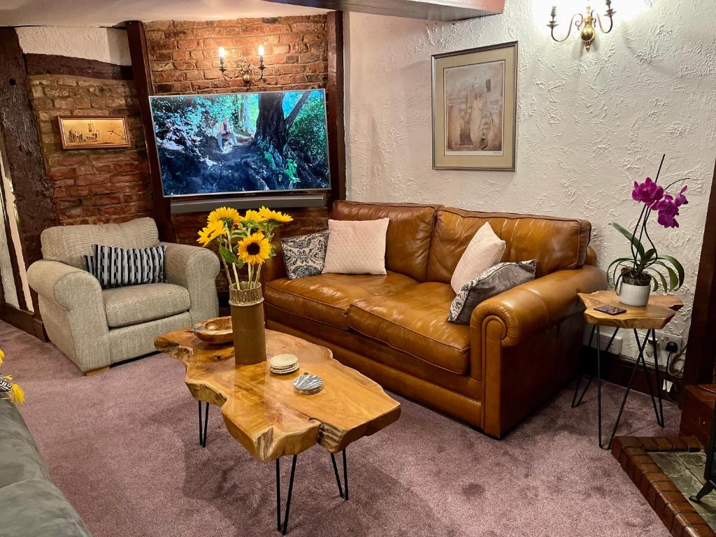 a living room with a brown leather couch and a table at Cathedral View in Gloucester