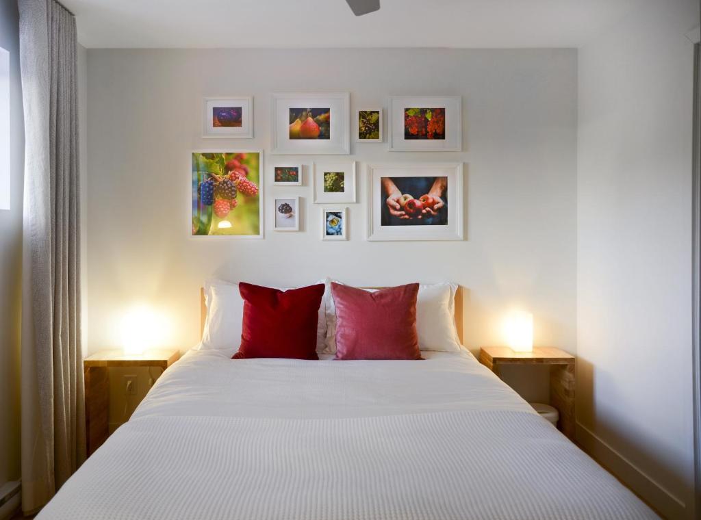 a bedroom with a white bed with red pillows at Le Camp Caché Shefford in Shefford