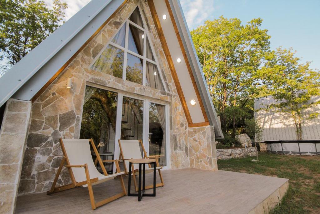 ein Haus mit zwei Stühlen auf einer Terrasse in der Unterkunft Vukova dolina in Cetinje