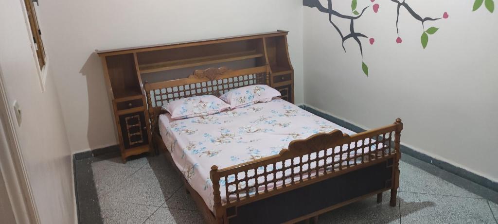 - une chambre avec un lit en bois et 2 oreillers dans l'établissement amine adnane, à Safi