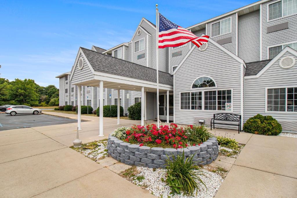 una casa con una bandera americana delante de ella en Microtel Inn and Suites Manistee, en Manistee