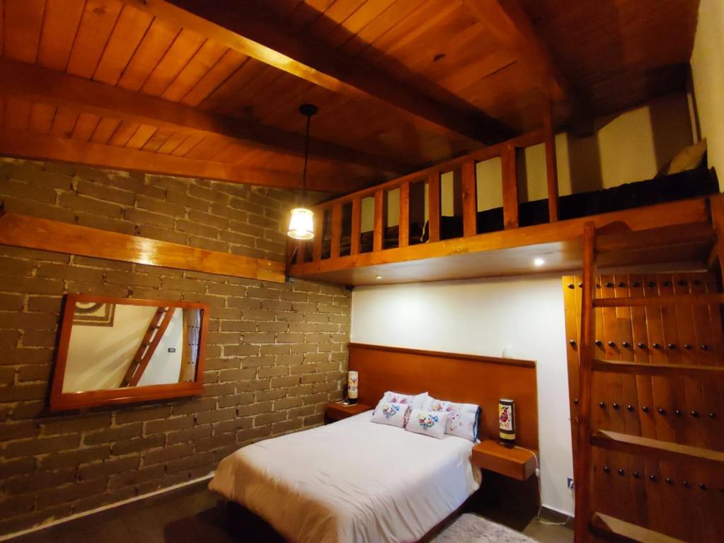 een slaapkamer met een bed in een bakstenen muur bij hermosa cabaña el rio in Zacatlán
