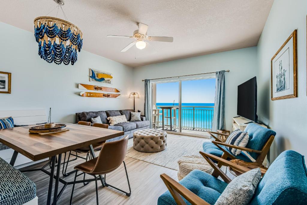 uma sala de estar com mesa e cadeiras e vista para o oceano em Pelican Isle 606 em Fort Walton Beach