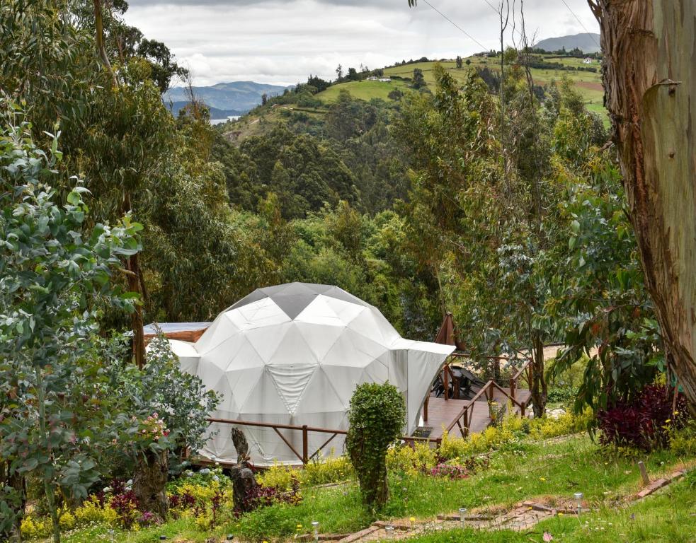 a white tent in the middle of a garden at Golden Glamping in Guatavita
