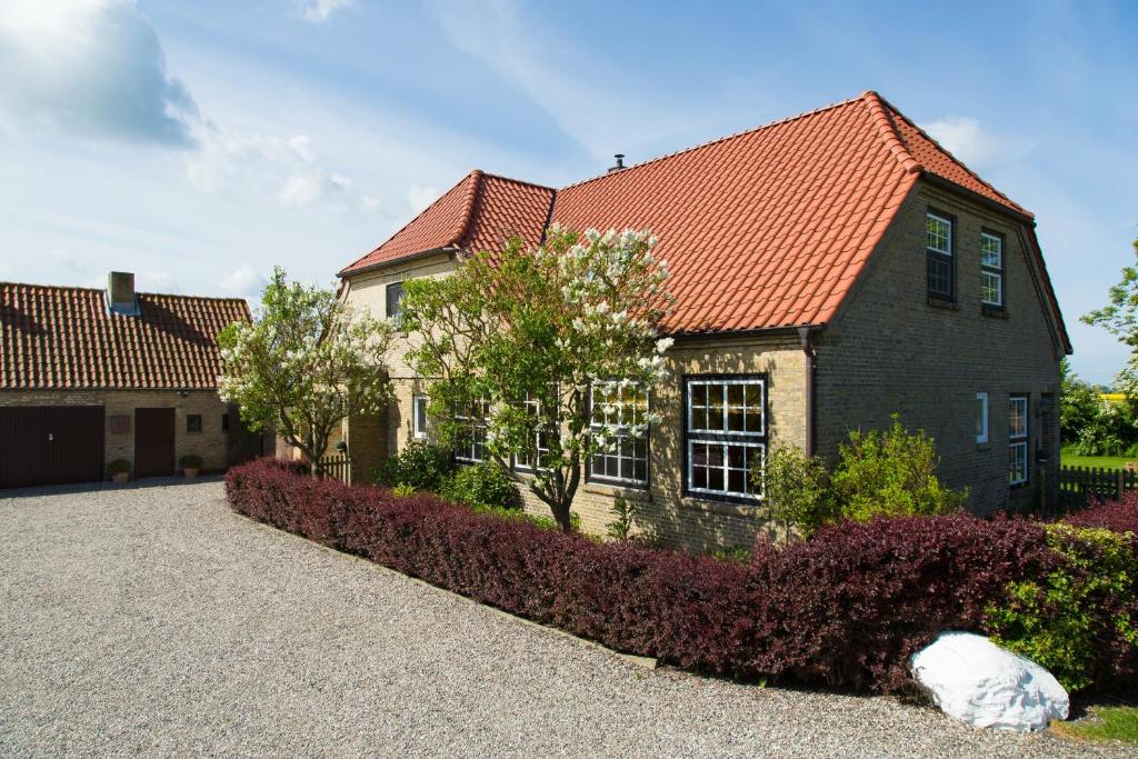 a house with a red roof on a driveway at Haus im Felde Whg 5 in Fehmarn