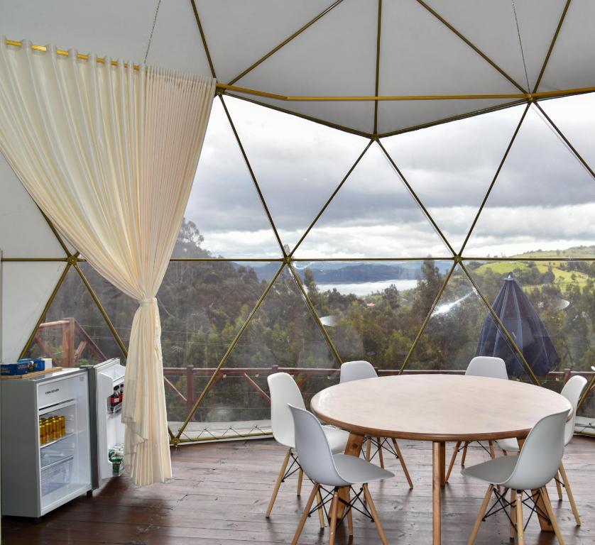 a room with a table and chairs in a tent at Golden Glamping in Guatavita