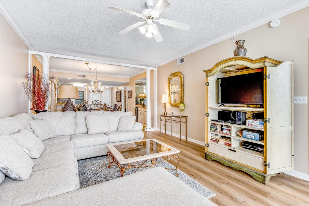 a living room with a white couch and a tv at Pearl 1305 in Navarre