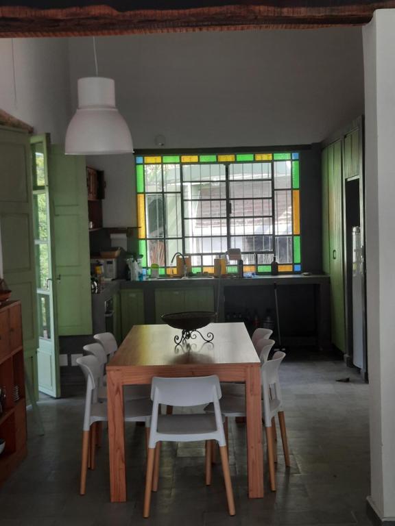 eine Küche mit einem Tisch und Stühlen sowie einem Fenster in der Unterkunft Casa en Camino del cuadrado Sierras de Córdoba in Río Ceballos