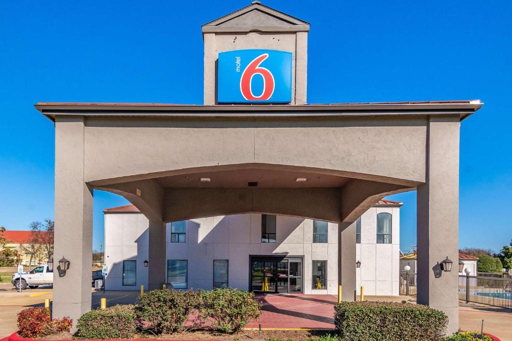 un edificio con un cartel encima en Motel 6-Ennis, TX, en Ennis