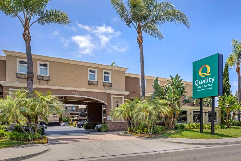 a hotel with palm trees in front of a building at Quality Inn & Suites Anaheim Maingate in Anaheim