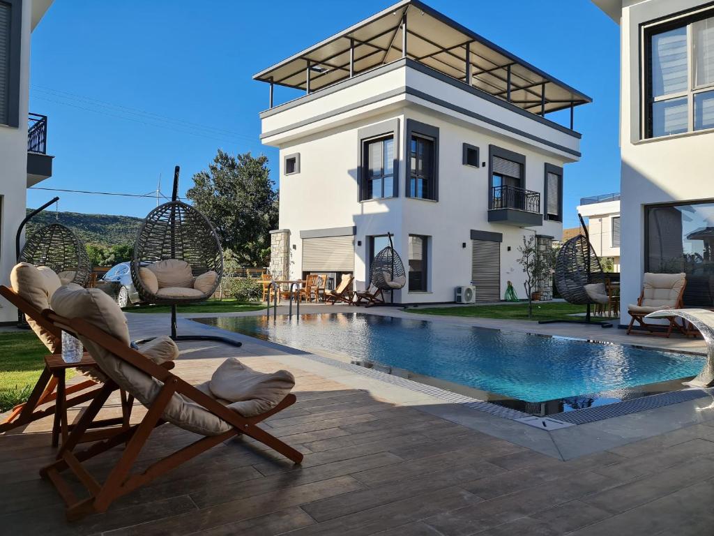 a villa with a swimming pool in front of a house at Villa Evasion D in Seferihisar