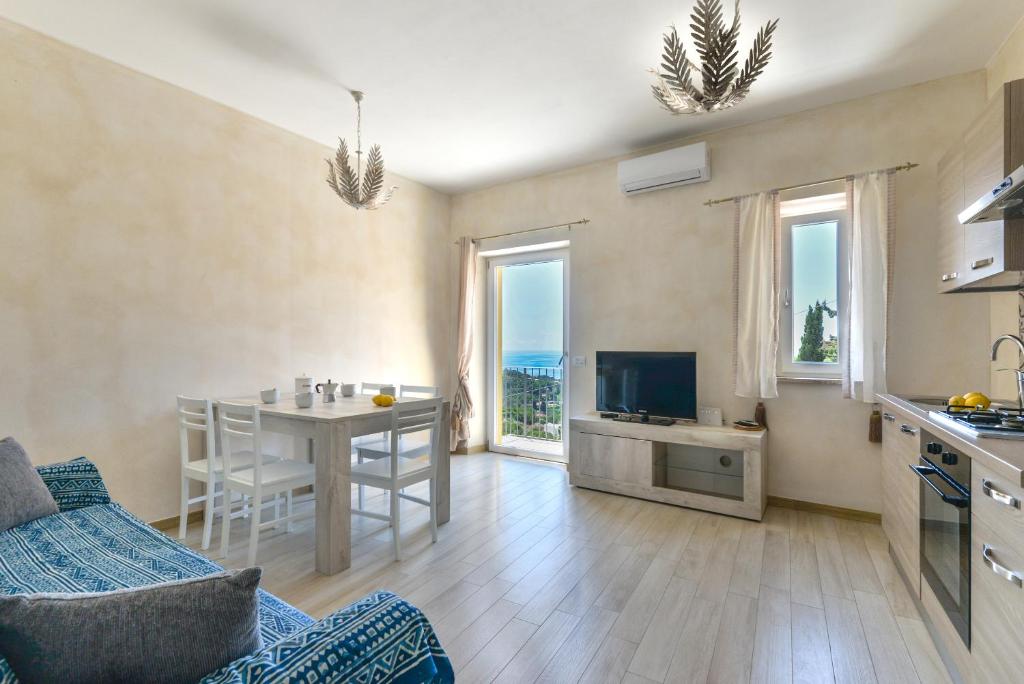 a kitchen and living room with a table and a television at Casa Bellavista in Capoliveri