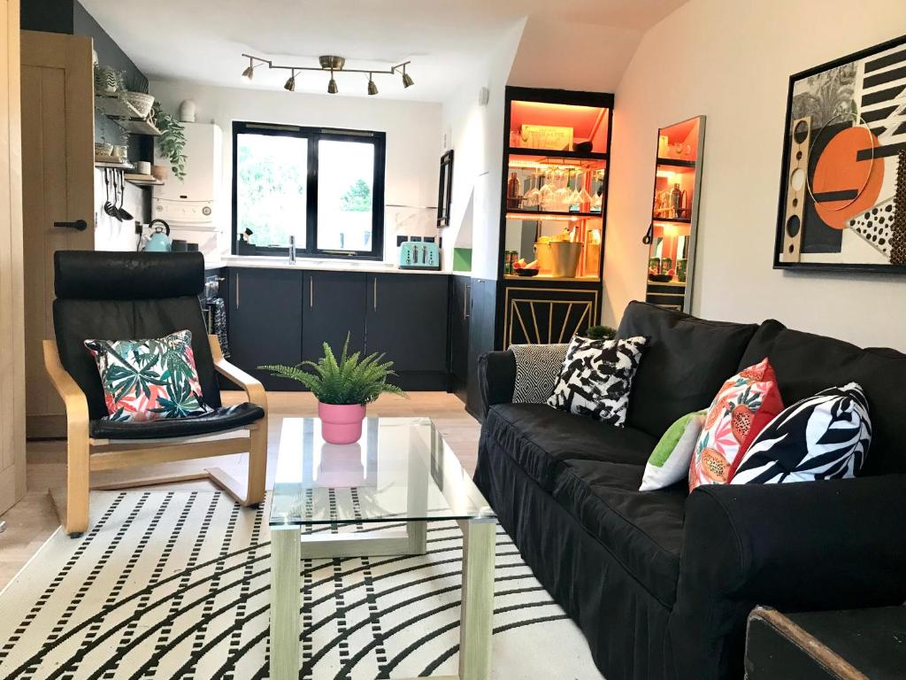 a living room with a black couch and a table at THE MORNINGSIDE APARTMENT Charming stylish apartment in the centre of Innerleithen in Innerleithen