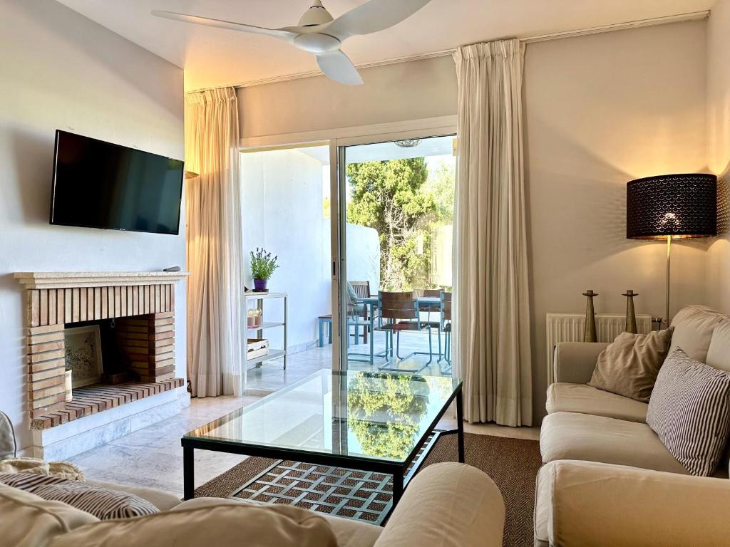 a living room with a fireplace and a tv at Blue House in Guadalmina Baja, with a large terrace overlooking the Golf in Marbella