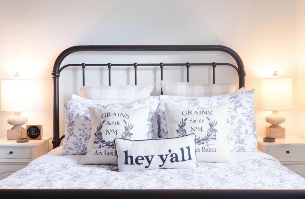 una cama con almohadas y un cartel que diga que lo harán en Hyde Park Carriage House, en Austin