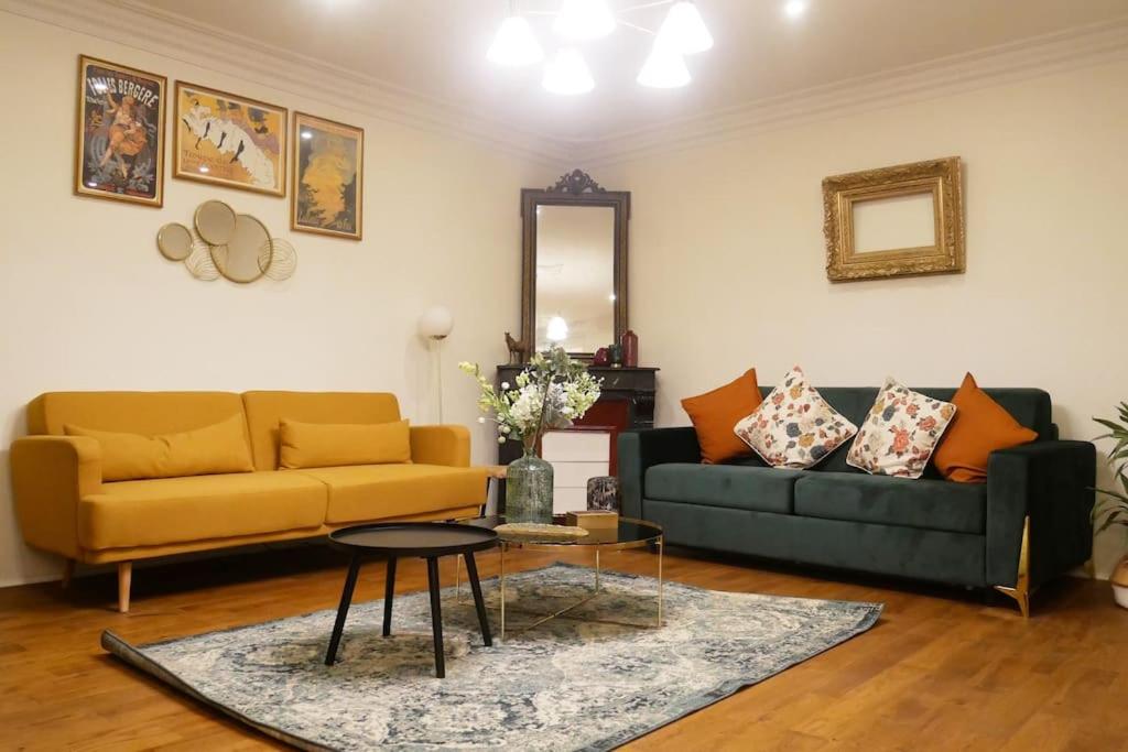 Sala de estar con 2 sofás y mesa en Appartement 2 étages Paris - Métro 9 Grands Boulevards - Folies Bergères en París