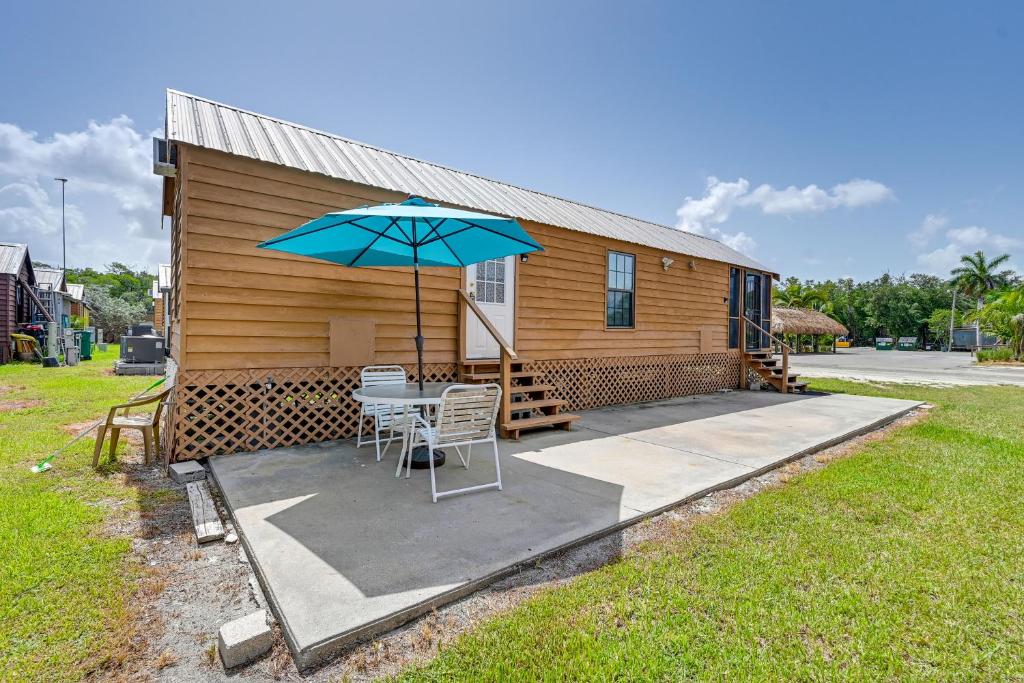 a small cabin with a table and an umbrella at Everglades Rental Trailer Cabin with Boat Slip! in Everglades City