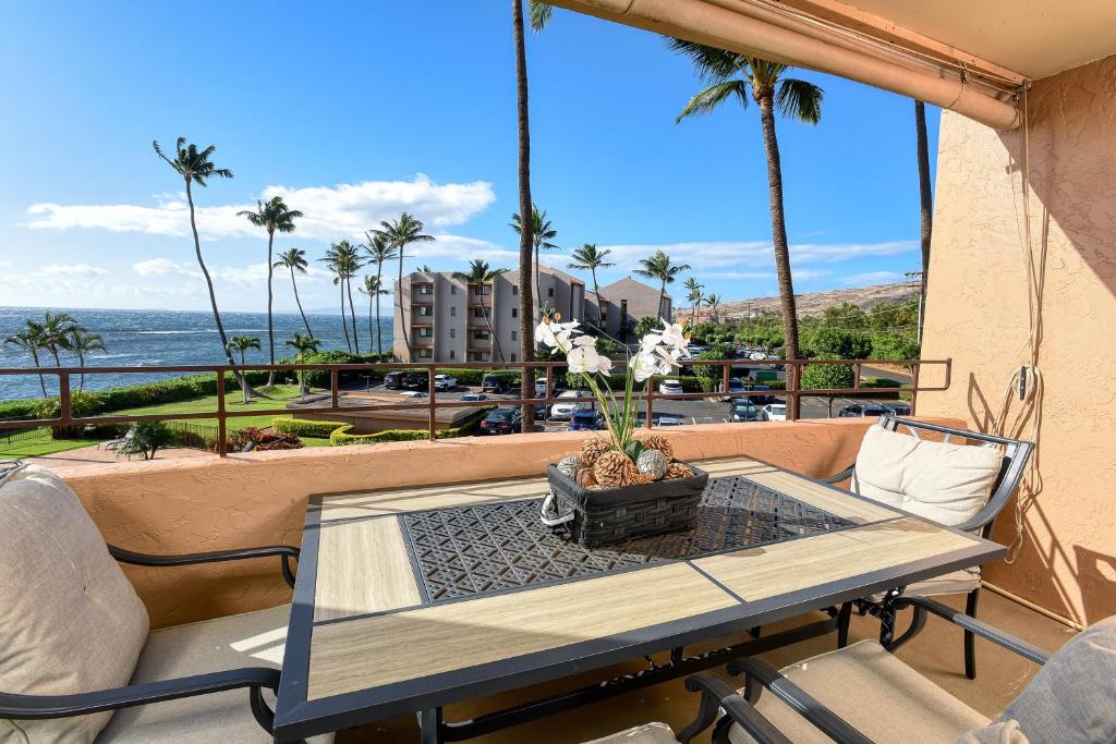 a table and chairs on a balcony with a view of the ocean at Island Sands Resort 302 in Wailuku
