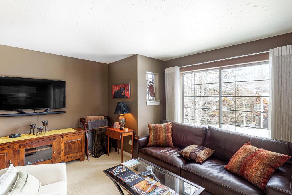 uma sala de estar com um sofá de couro e uma televisão de ecrã plano em Northstar 22 - The North Star em Telluride