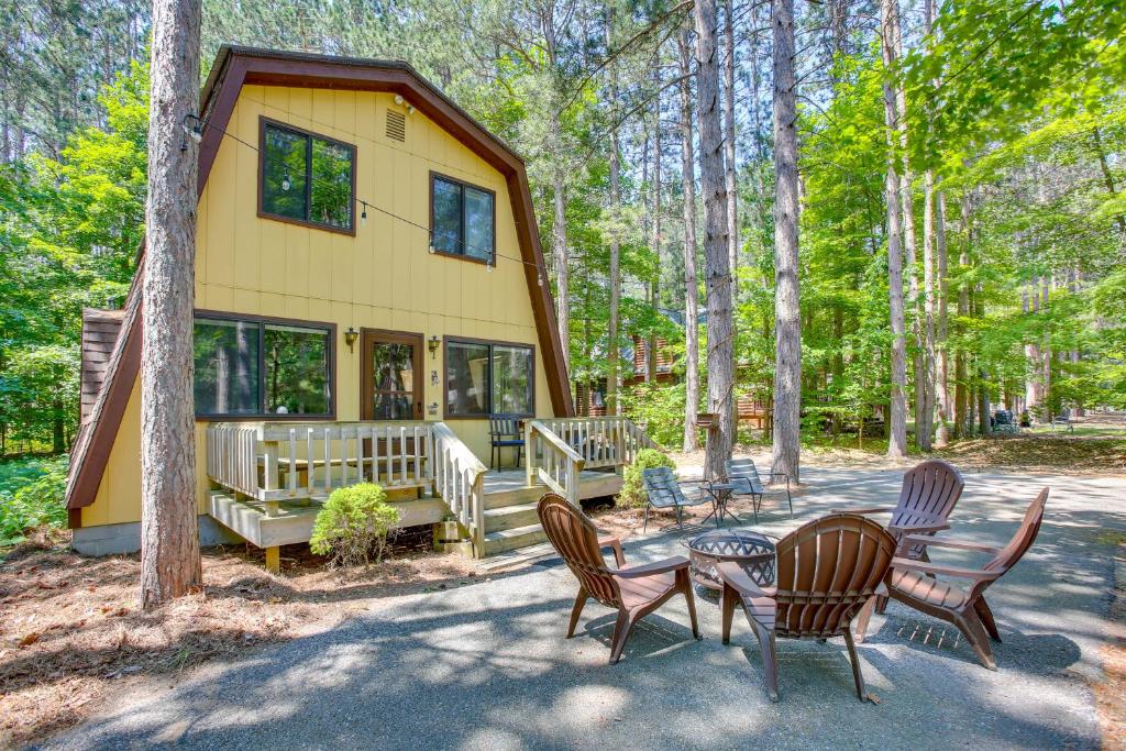 una pequeña casa en el bosque con una mesa y sillas en Crystal Mountain Cabin with Cozy Fireplace!, en Thompsonville