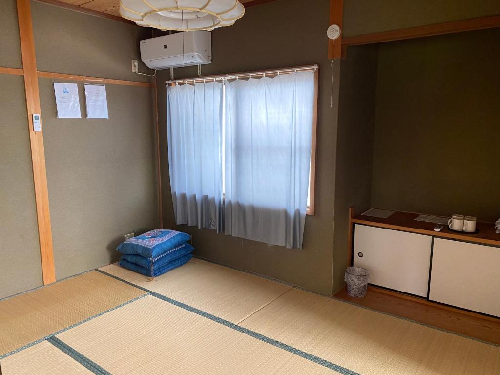 um quarto com uma janela e um quarto com uma mesa em シェアハウスの和室or洋室 24時間スーパー徒歩5分 共同ワークスペース有 em Gifu