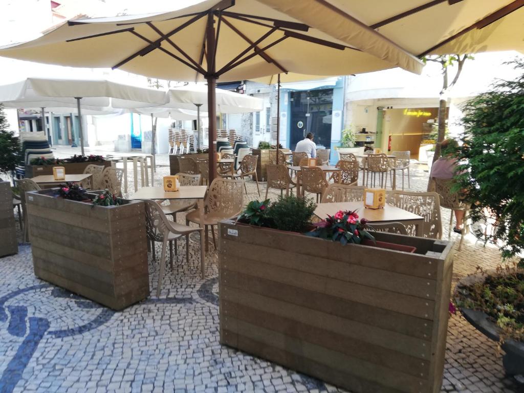 Un restaurante con mesas, sillas y sombrillas. en Aveiro Soul & Heart apartment, en Aveiro