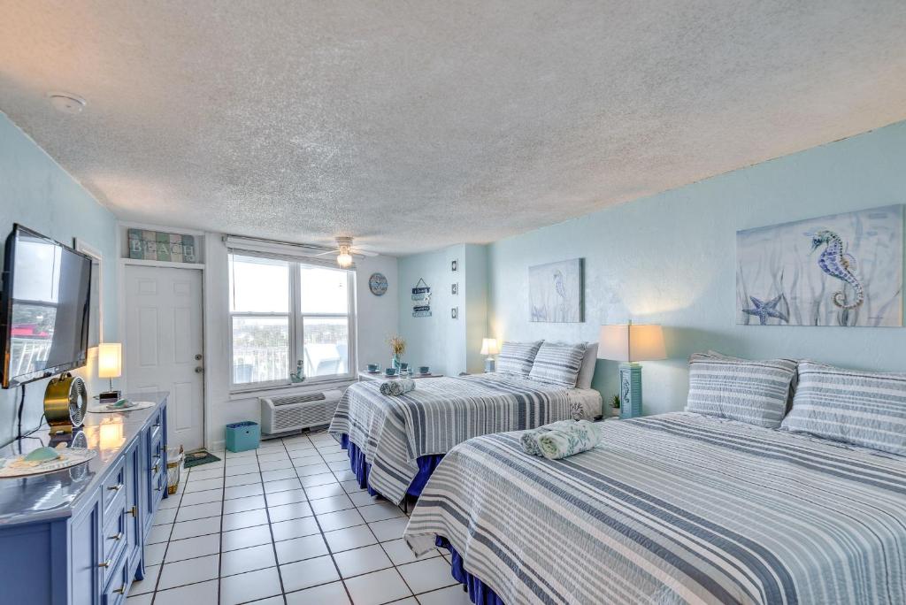 Dieses blaue Zimmer verfügt über 2 Betten und einen TV. in der Unterkunft Daytona Beach Studio with Ocean View and Amenities! in Daytona Beach
