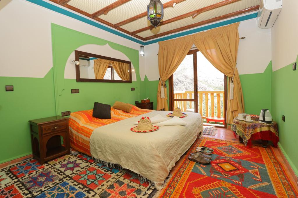 a bedroom with a bed in a room with green walls at Atlas Prestige in Imlil