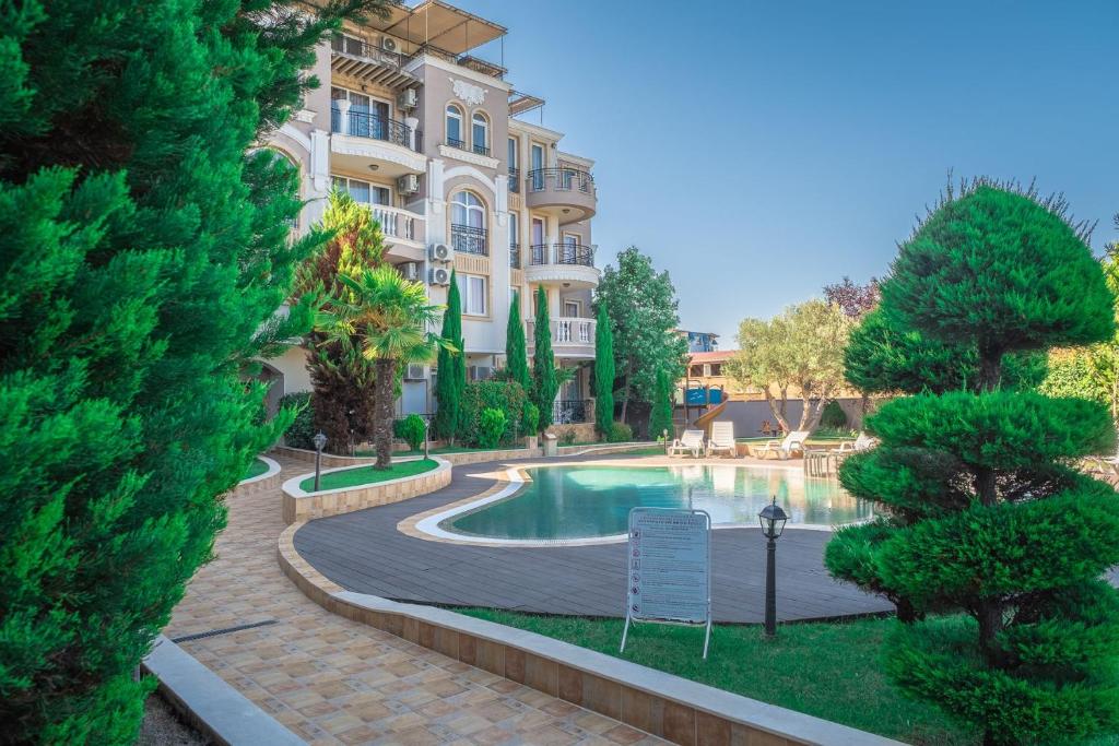 a building with a swimming pool in front of a building at Melia lux apartment in Ravda