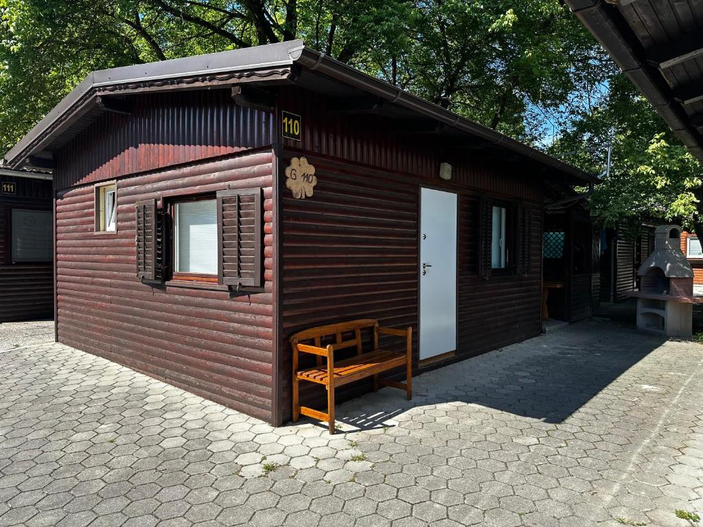 un pequeño edificio rojo con un banco delante en OASIS Aqualuna & Terme Olimia G110 en Podčetrtek