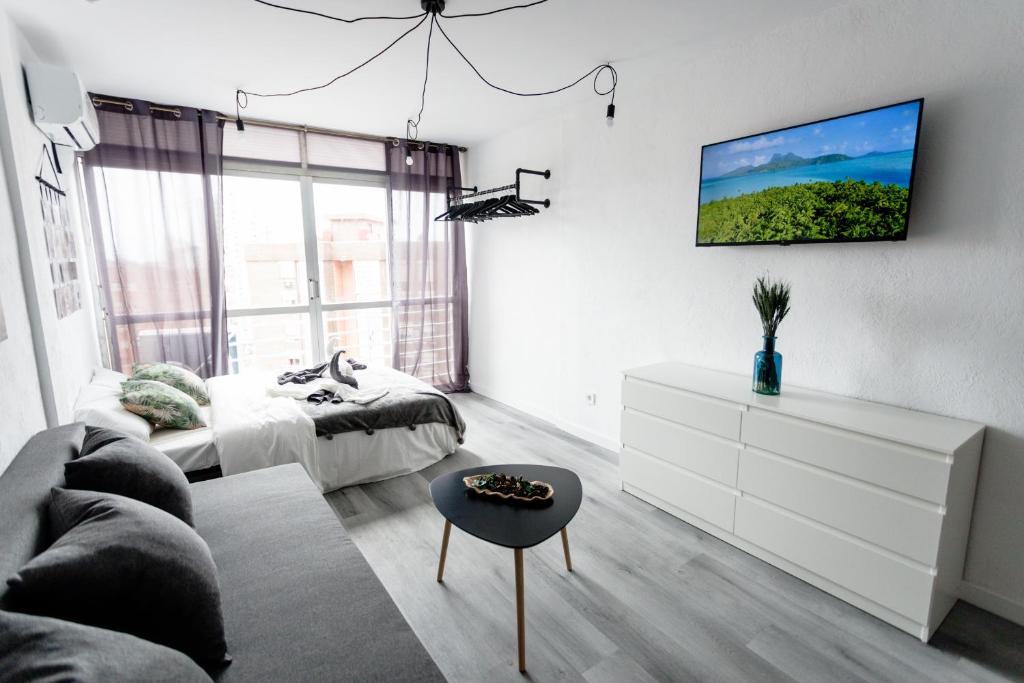 a living room with a couch and a tv on the wall at Modern studio with see and city view in Benidorm