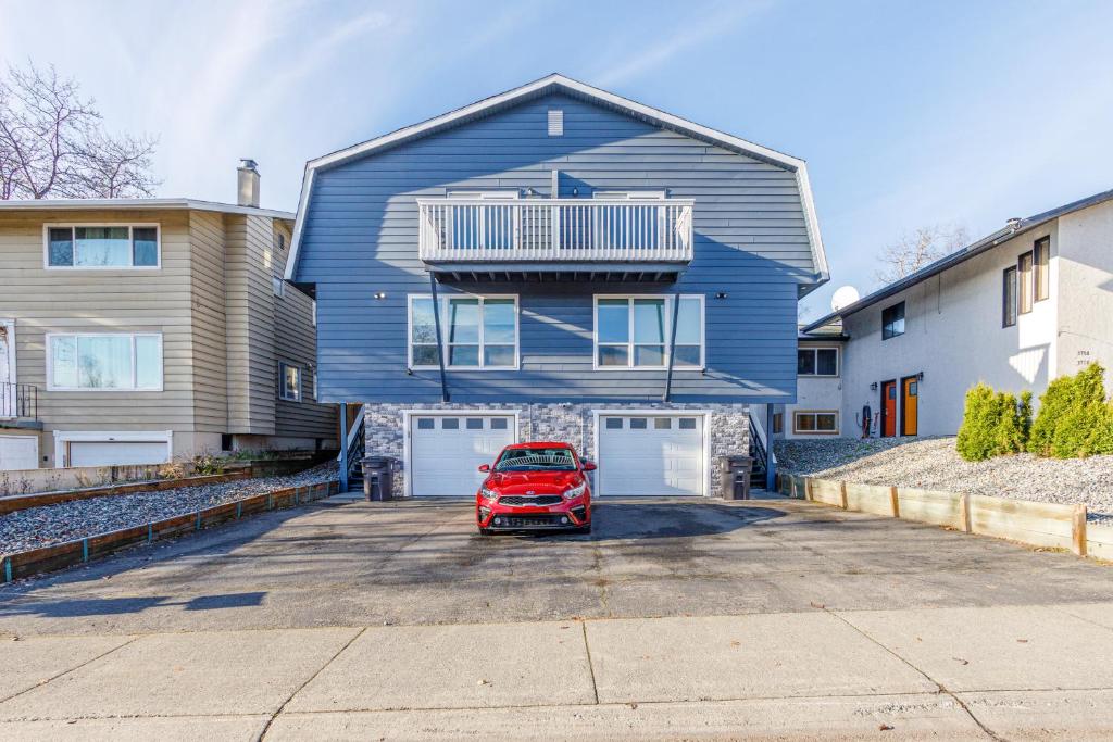 une voiture rouge garée devant une maison bleue dans l'établissement Midtown Anchorage Basecamp, à Anchorage