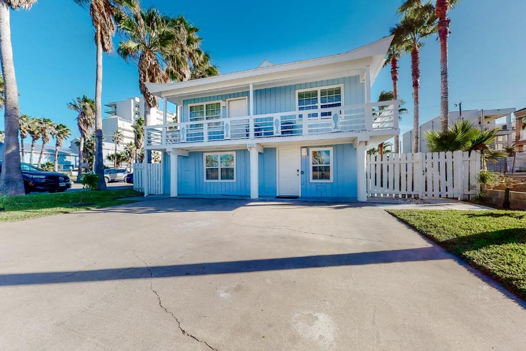 una casa blanca con palmeras delante en Lazy Seagull Beach House, en South Padre Island