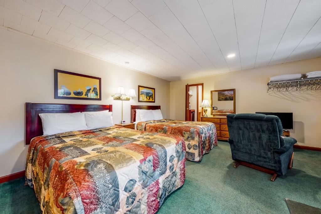 una habitación de hotel con 2 camas y una silla en Riverbank Connecting Rooms 3 & 5, en Lincoln