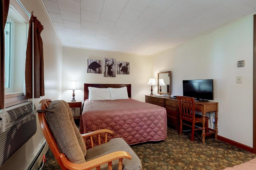 林肯的住宿－Riverbank Connecting Motel Rooms 4 & 6，酒店客房配有一张床、一张书桌和一台电视。