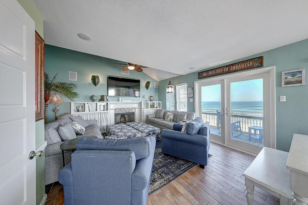 a living room with a couch and chairs and a television at Lost Colony #5 in Port Aransas