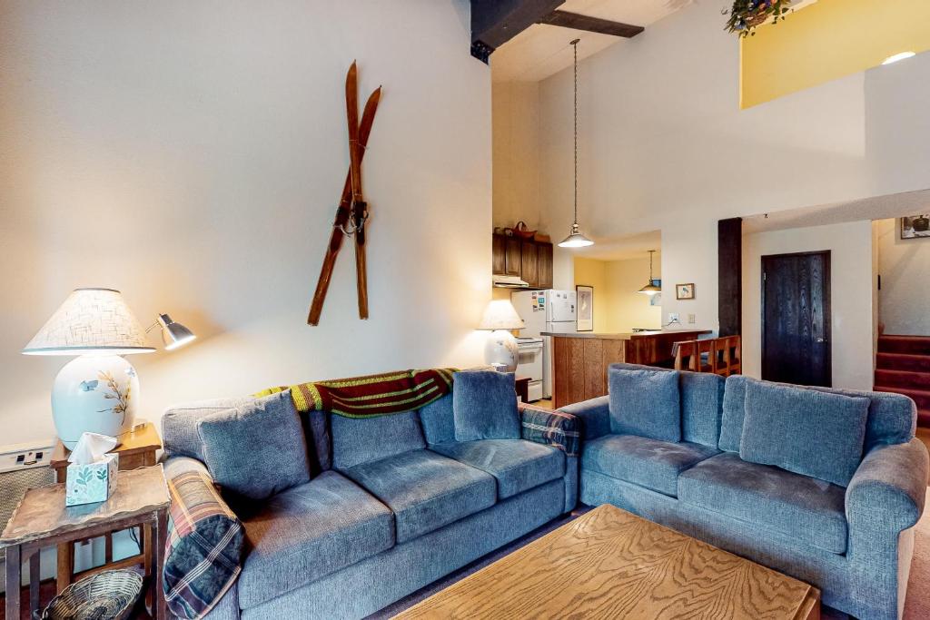 a living room with two blue couches and a table at Crestview 70 in Mammoth Lakes