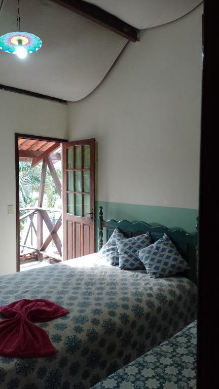 a bedroom with a bed and a large window at Casa - suites com varanda in Conde