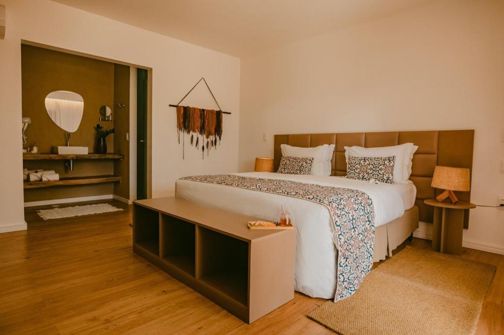 a bedroom with a large bed and a mirror at Dolphin Hotel in Fernando de Noronha