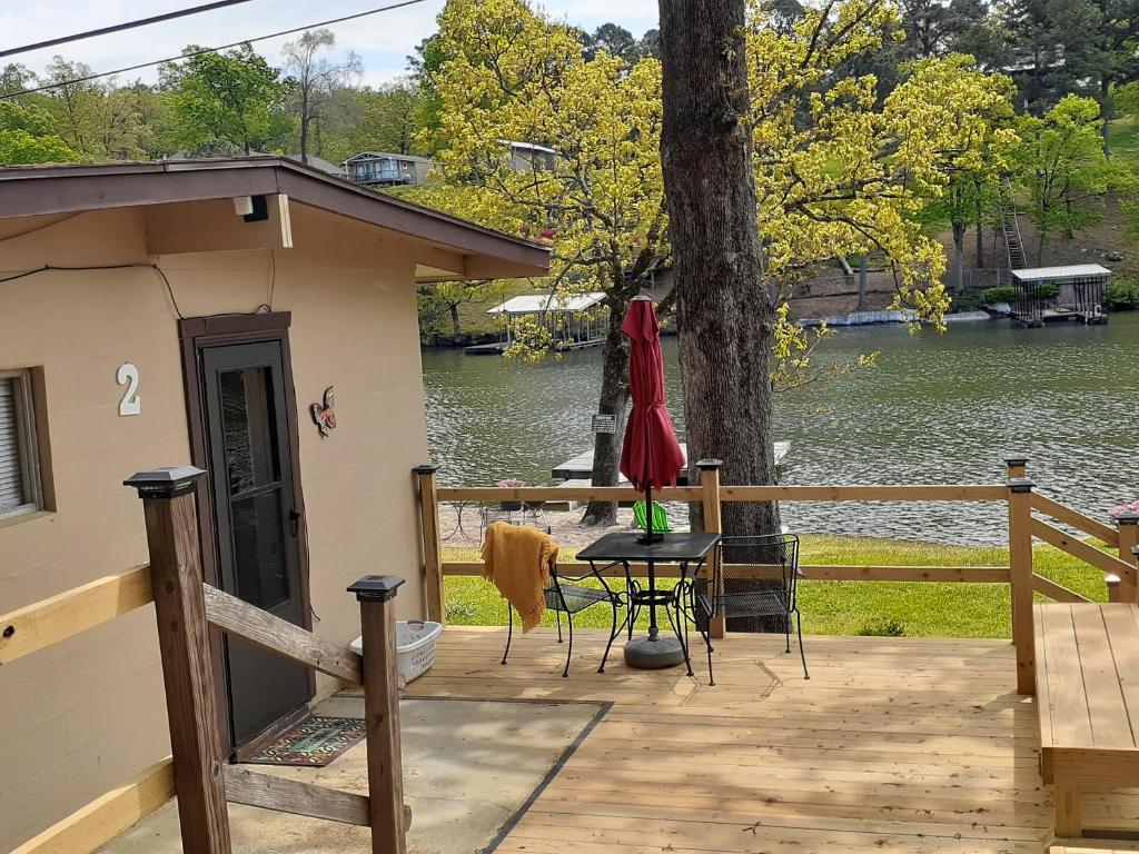 a patio with a table and a red umbrella at #02 - Unique Lakeside Studio Cottage- Pet Friendly in Hot Springs
