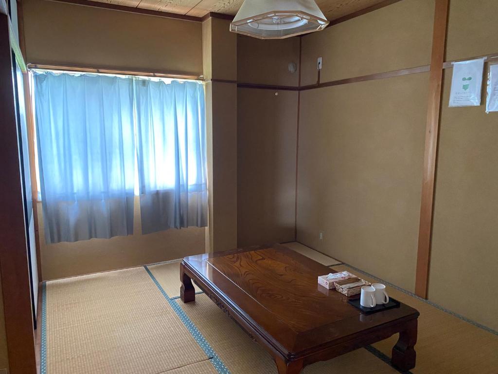 a small room with a table and a window at シェアハウスの和室7畳or洋室 24時間スーパー徒歩5分 共同ワークスペース有 