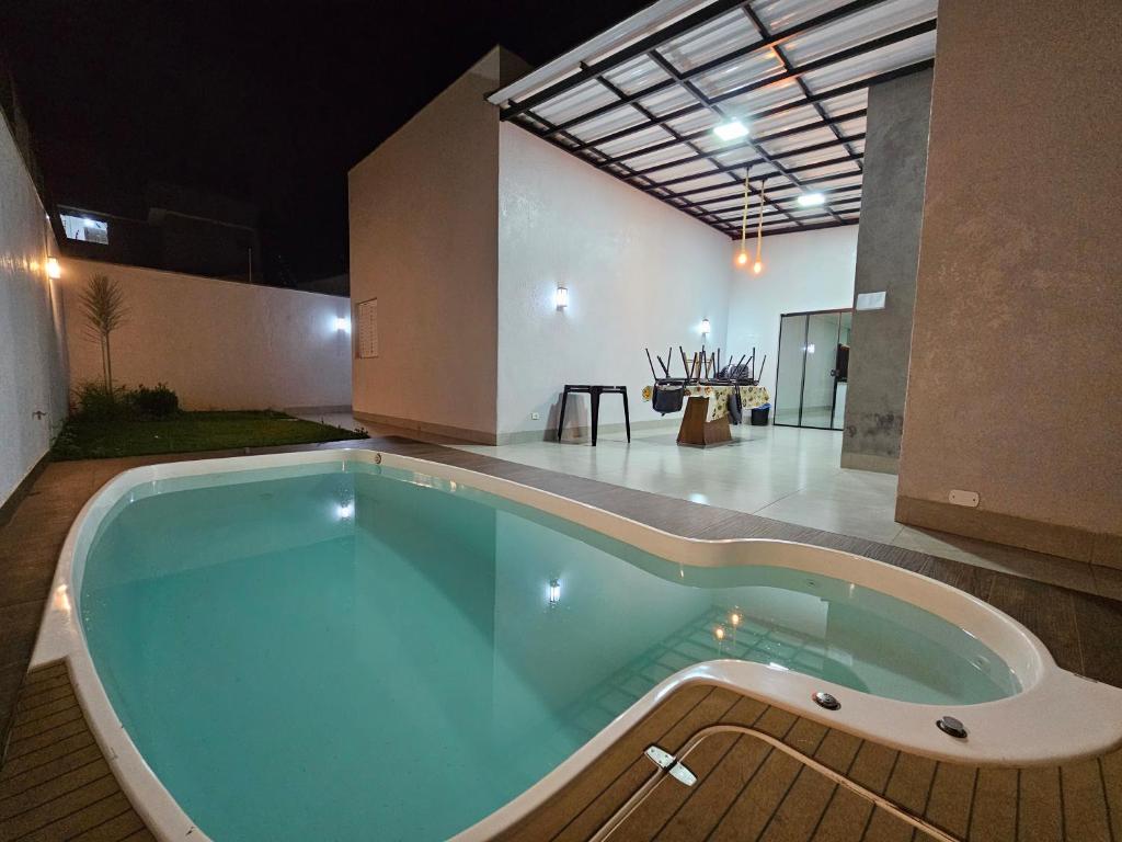 uma grande piscina no meio de uma casa em Casa do Sonho, Piscina, Sinuca, Churrasqueira em Maringá