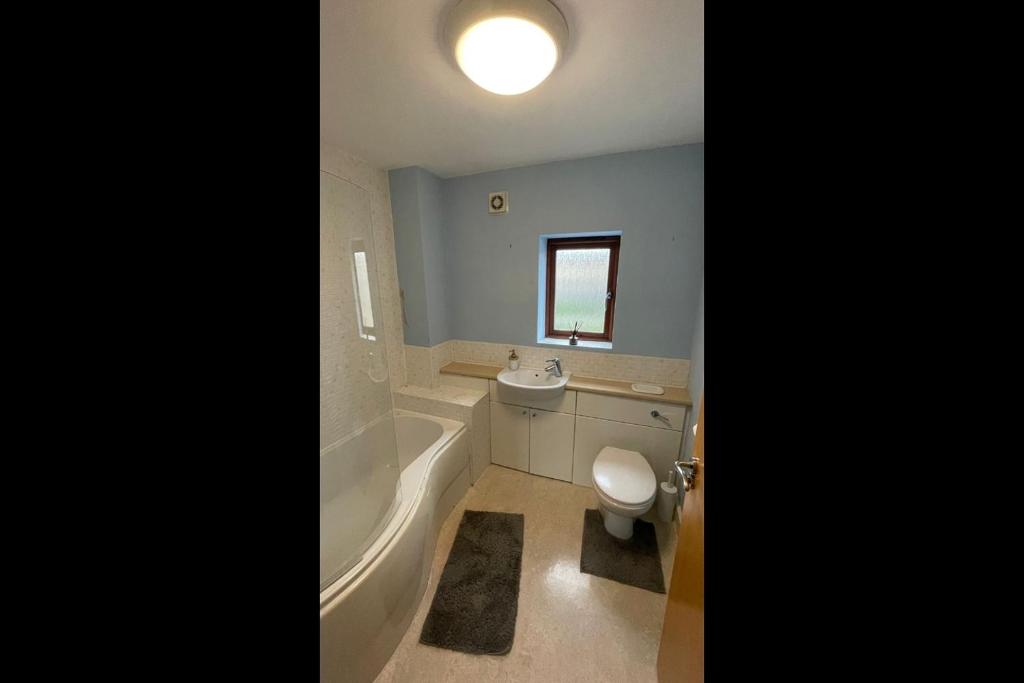 a bathroom with a tub and a toilet and a sink at The Comfy place Shared in Dallington
