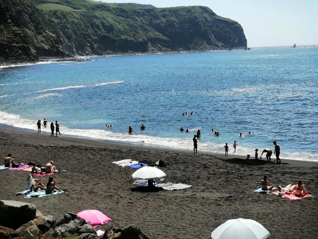 a group of people on a beach near the water at Casa Dos Mosteiros in Mosteiros