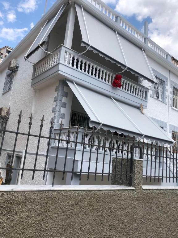 a white building with a balcony and a fence at Villa K & N in Sarandë