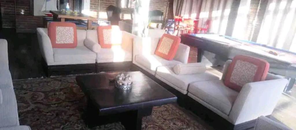 Loft DT con mesa de billar في تيخوانا: غرفة معيشة مع كنب وطاولة قهوة