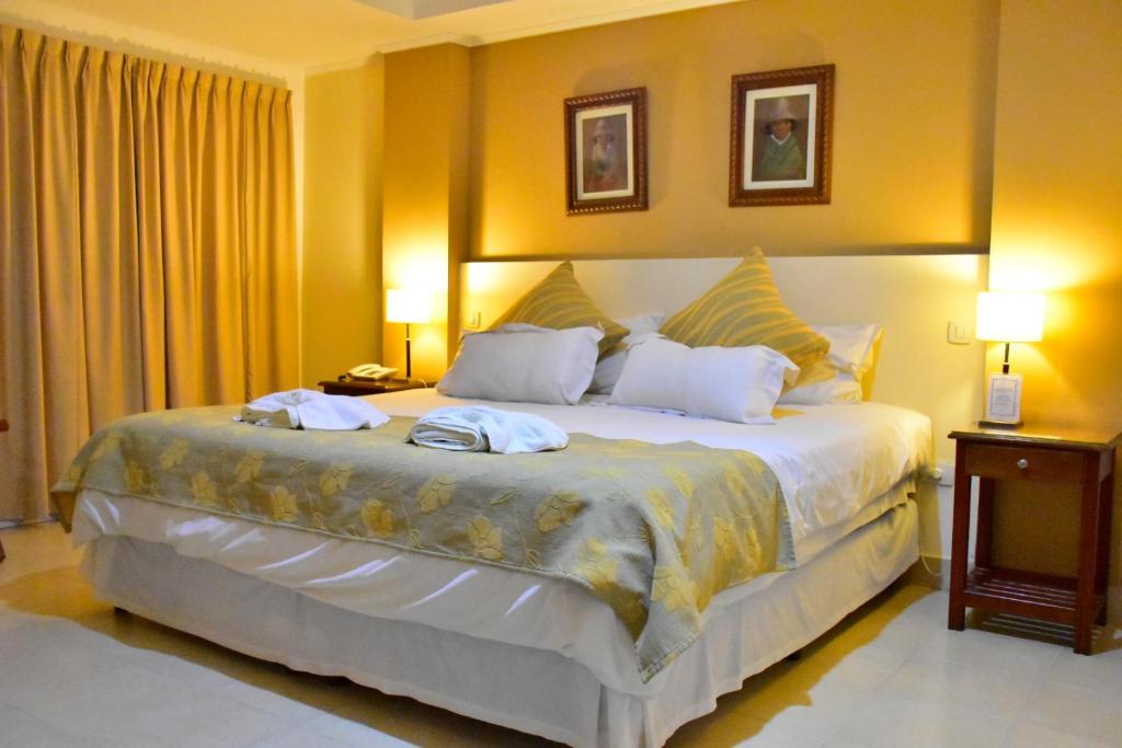 a bedroom with a large bed with two towels on it at Hotel Astur in Salta