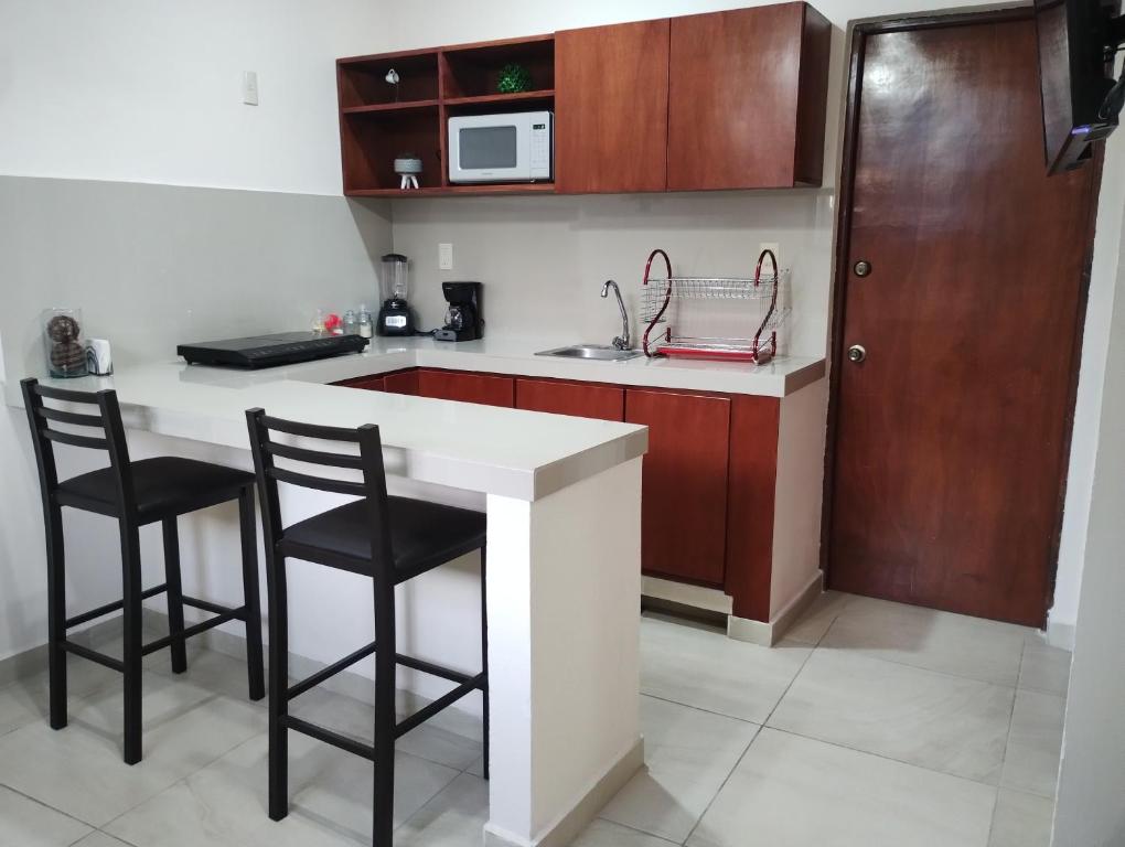 eine Küche mit zwei Barhockern und einem Waschbecken in der Unterkunft Departamento México in Tampico